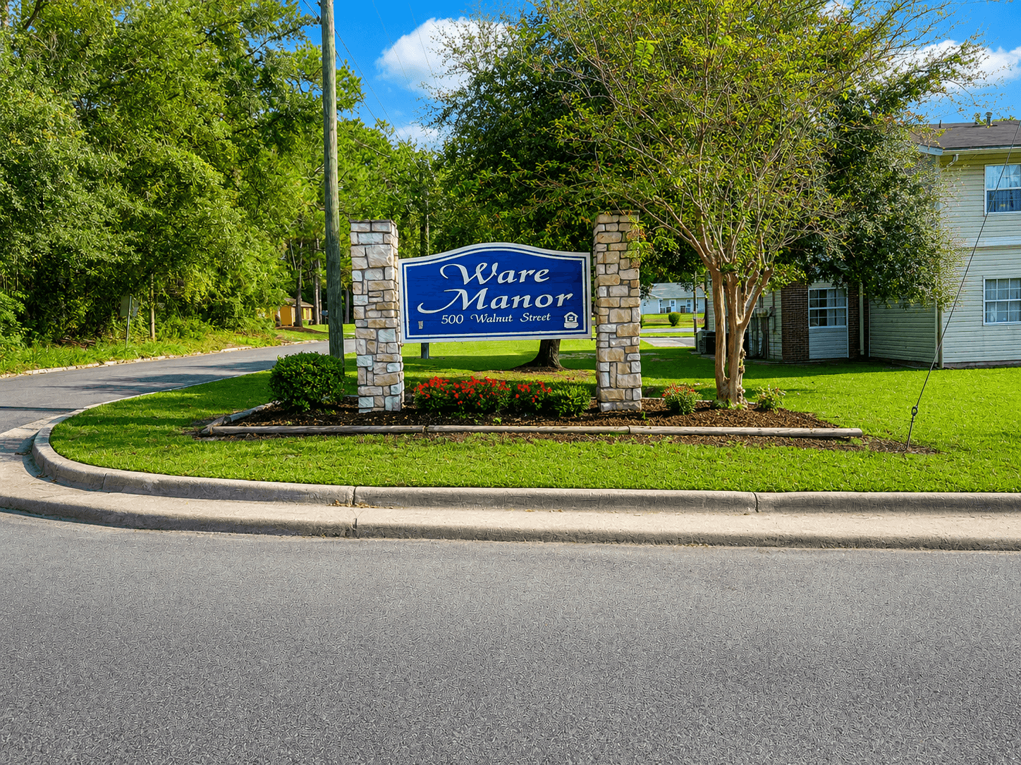 A sign that says "Ware Motor" stands in front of a house.